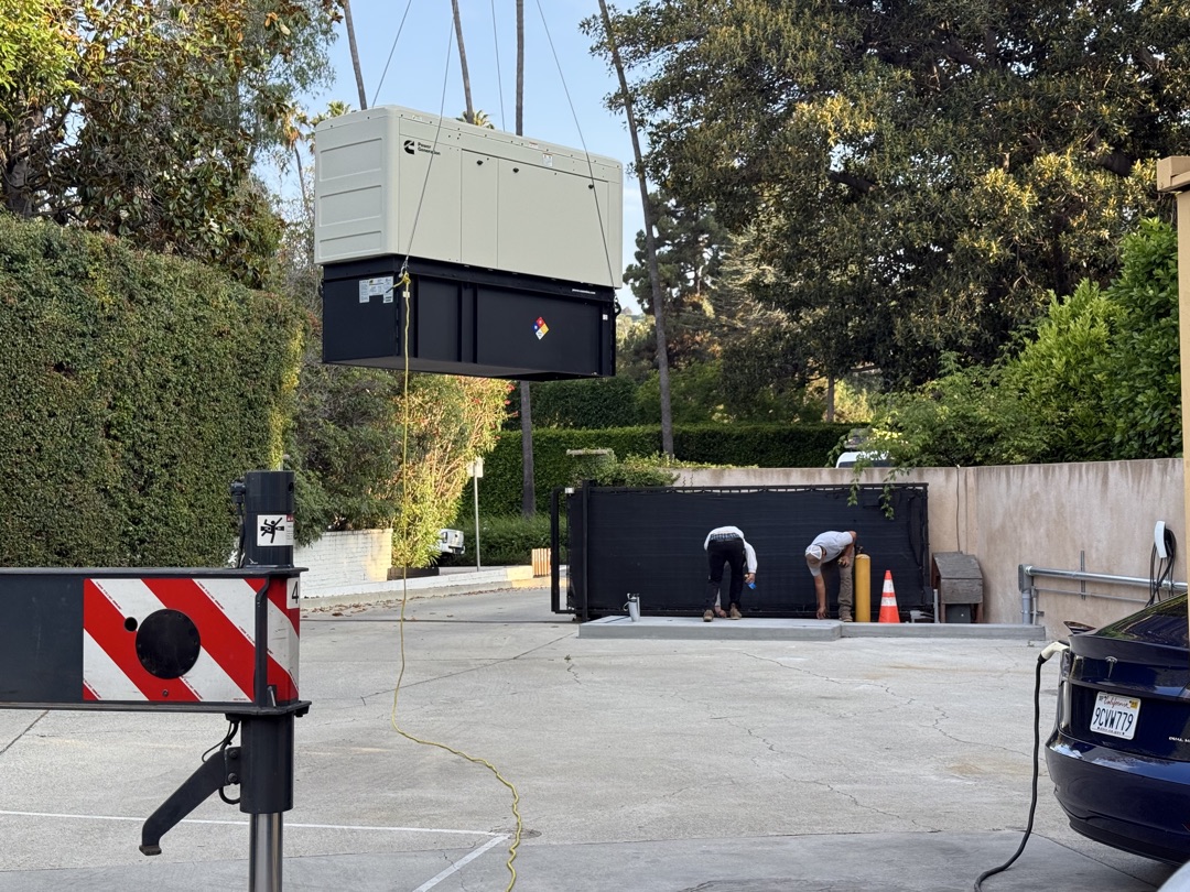 Cummins commercial generator being crane-lifted into position at a Los Angeles property — installation by Burlingame Brothers Electric